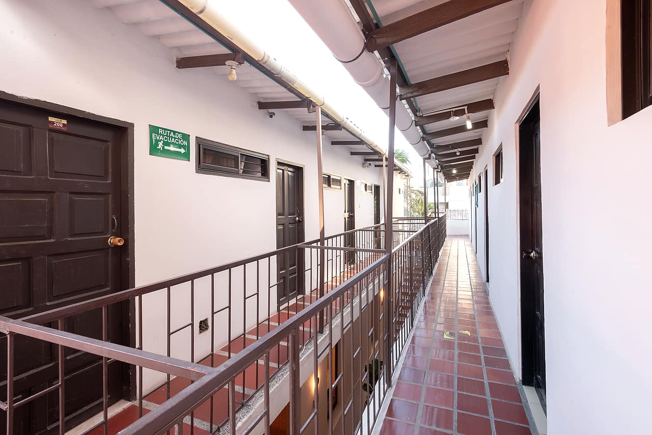 Balcón colonial de la planta alta con barandas de hierro sobre techos de teja